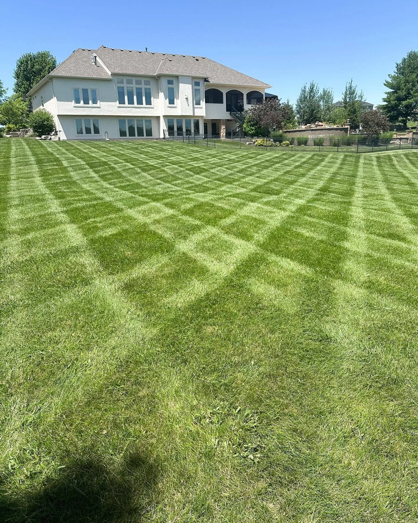 Professional lawn mowing with signature diamond striping pattern